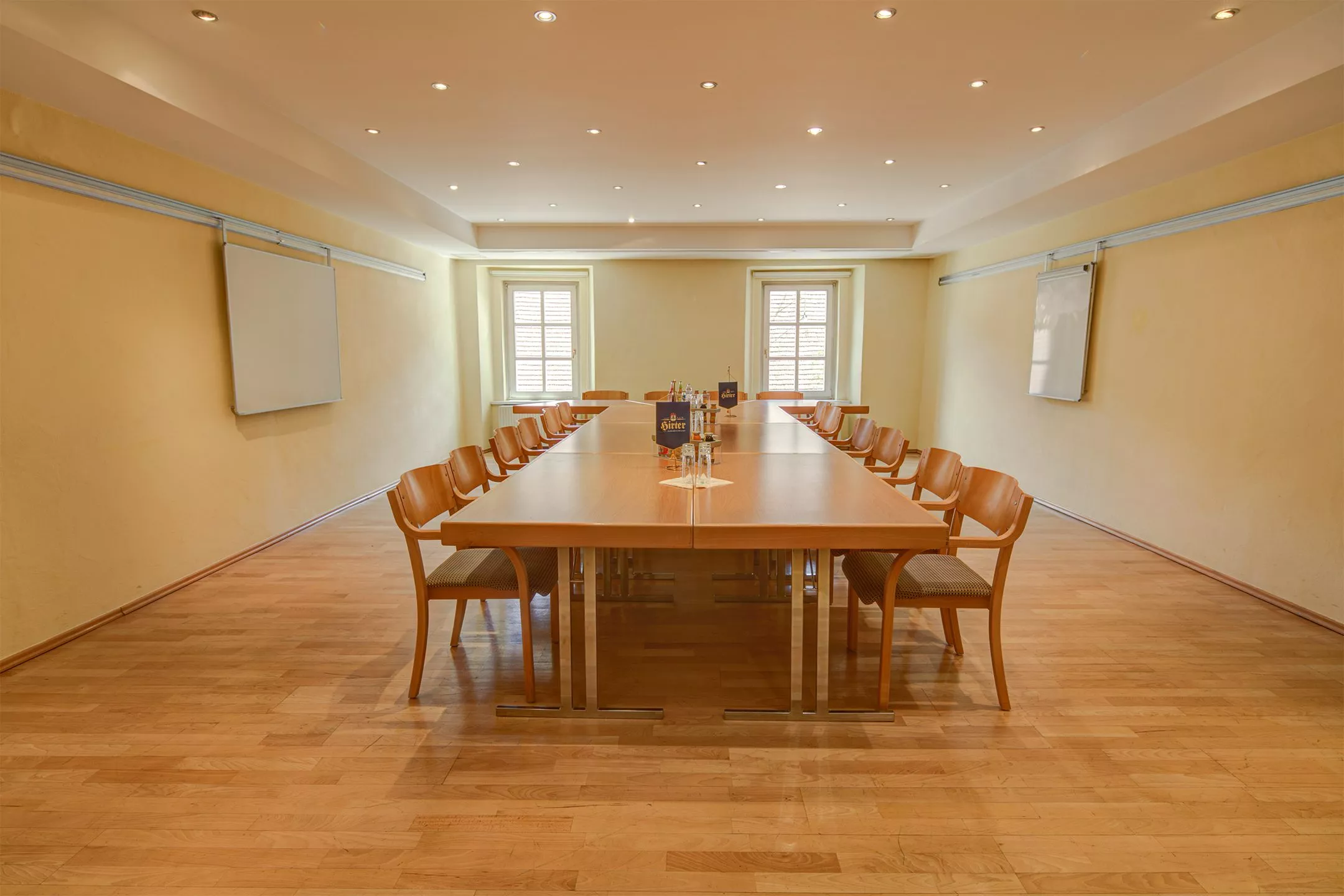 Ein großer, heller Konferenzraum mit einem langen Tisch für bis zu 20 Personen und Whiteboards an den Wänden.